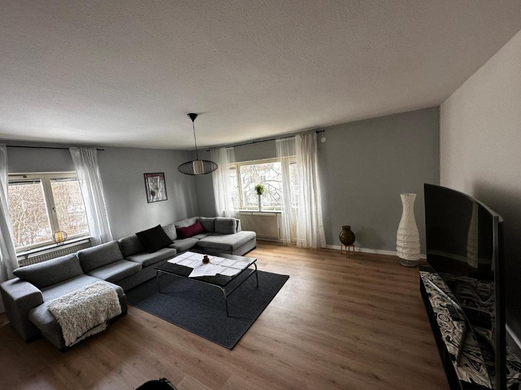 a living room with a couch and a tv at Ljungaverk Stor Lägenhet Med Öppen Spis in Ljungaverk