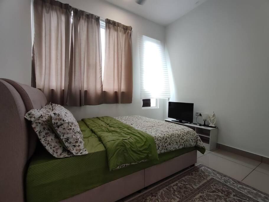 een slaapkamer met een bed met groene lakens en een raam bij 88 Homestay @ Palmyra Residences in Kajang