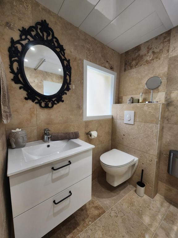 uma casa de banho com um lavatório, um WC e um espelho. em Le Beffroi de Gaston em Aix-en-Provence