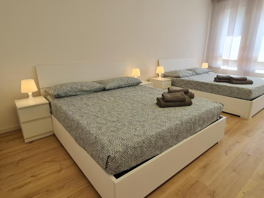Dos camas en un dormitorio con dos lámparas. en Infinity Collection, en Padua