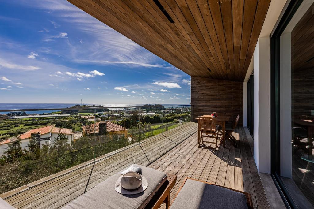 a balcony with a view of the ocean from a house at Quinta das Camélias - Açores in Ponta Delgada