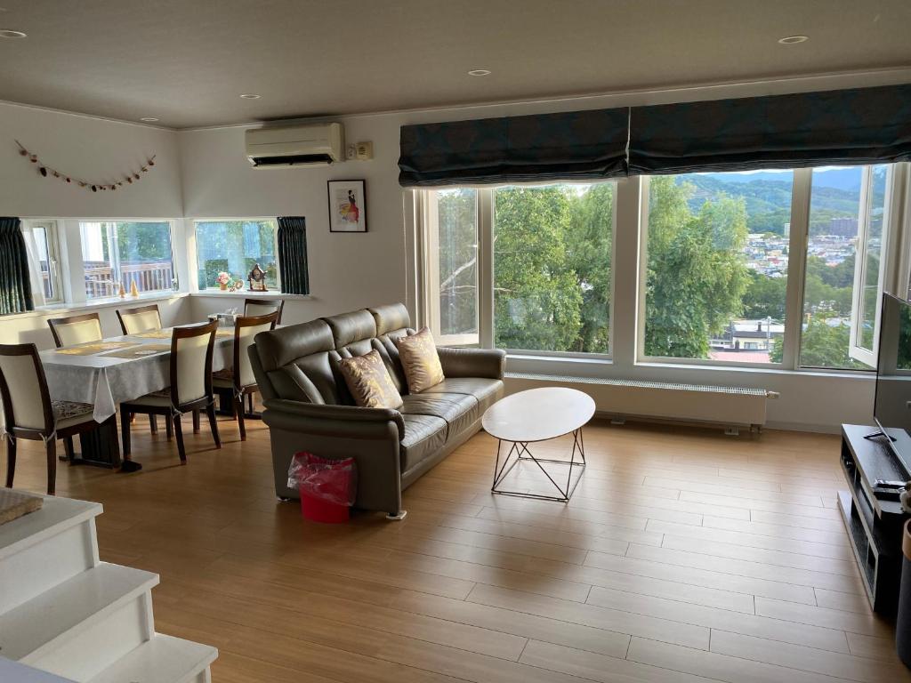 uma sala de estar com um sofá e uma mesa em 民泊森の家 em Moiwashita
