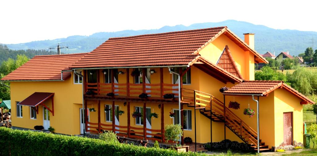 a yellow house with a red roof at Casa Ildikó in Sovata