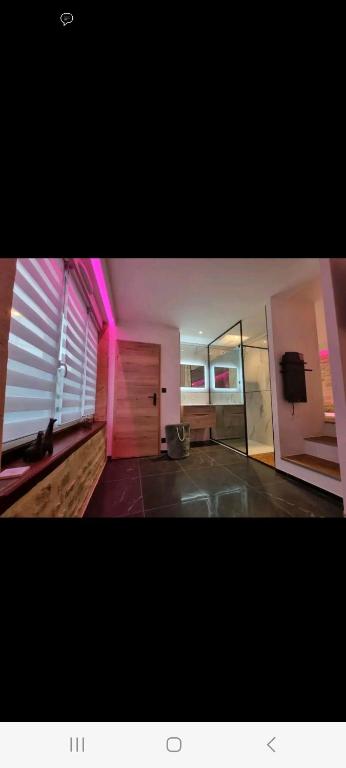 a living room with a room with pink lights at Romantique room in Charleville-Mézières