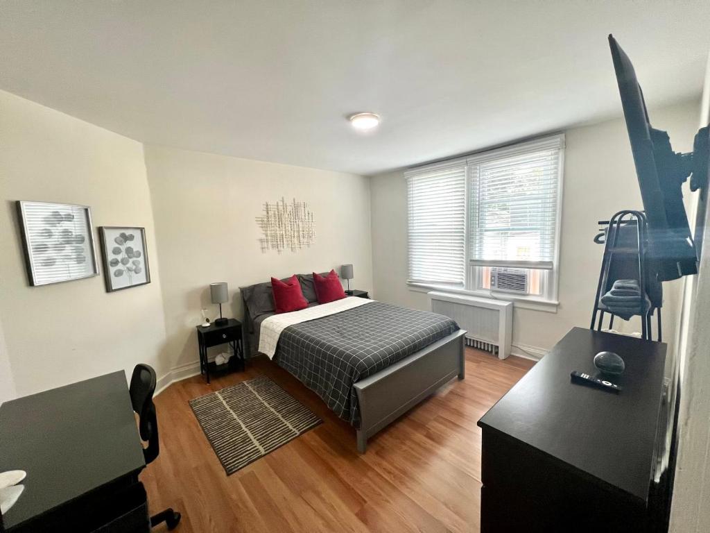 Un dormitorio con una cama con almohadas rojas y una ventana en 8-A Diamond in Yonkers, NY, en Yonkers