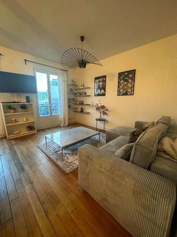 un salon avec un canapé et une table en verre dans l'établissement Le doux refuge à 5mn Paris & 10mn Stade de France, à Saint-Ouen