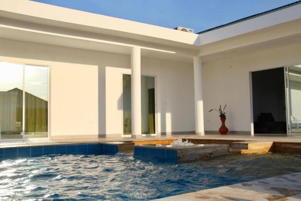 ein Haus mit Pool davor in der Unterkunft Casa campestre californiana con piscina privada in El Brasil