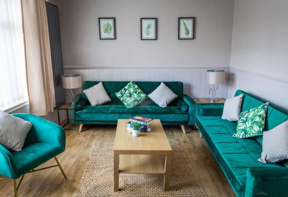 uma sala de estar com sofás verdes e uma mesa de centro em Comfort at Keldy em Tettenhall