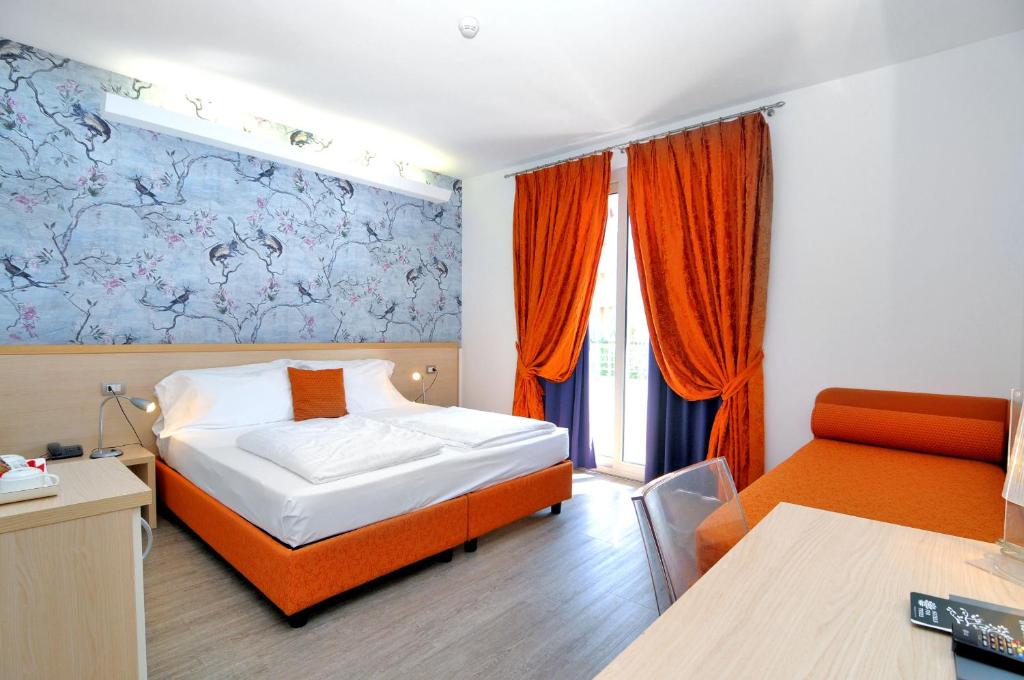 a hotel room with a bed and a chair at Eco Hotel Cleofe in Caorle