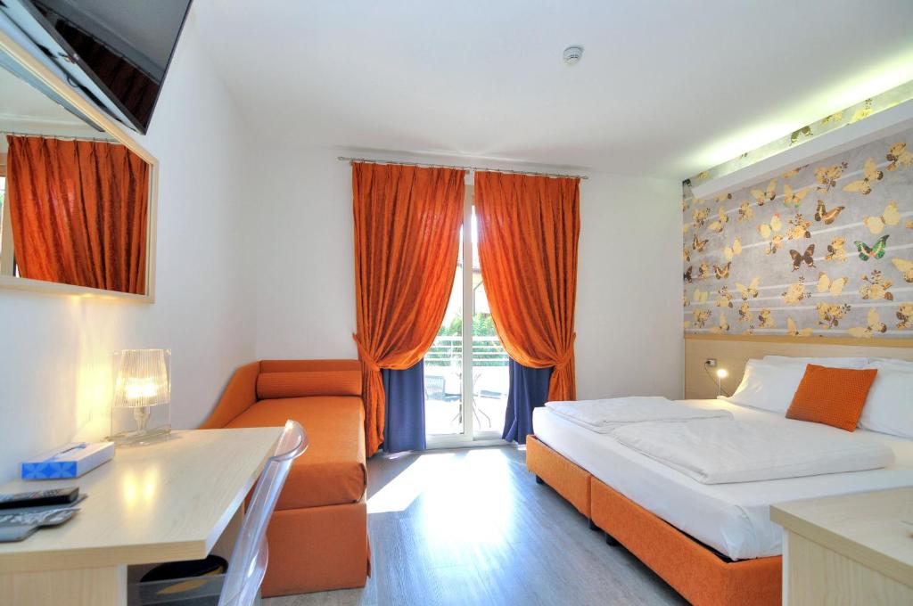 a bedroom with a bed and a couch and a desk at Eco Hotel Cleofe in Caorle