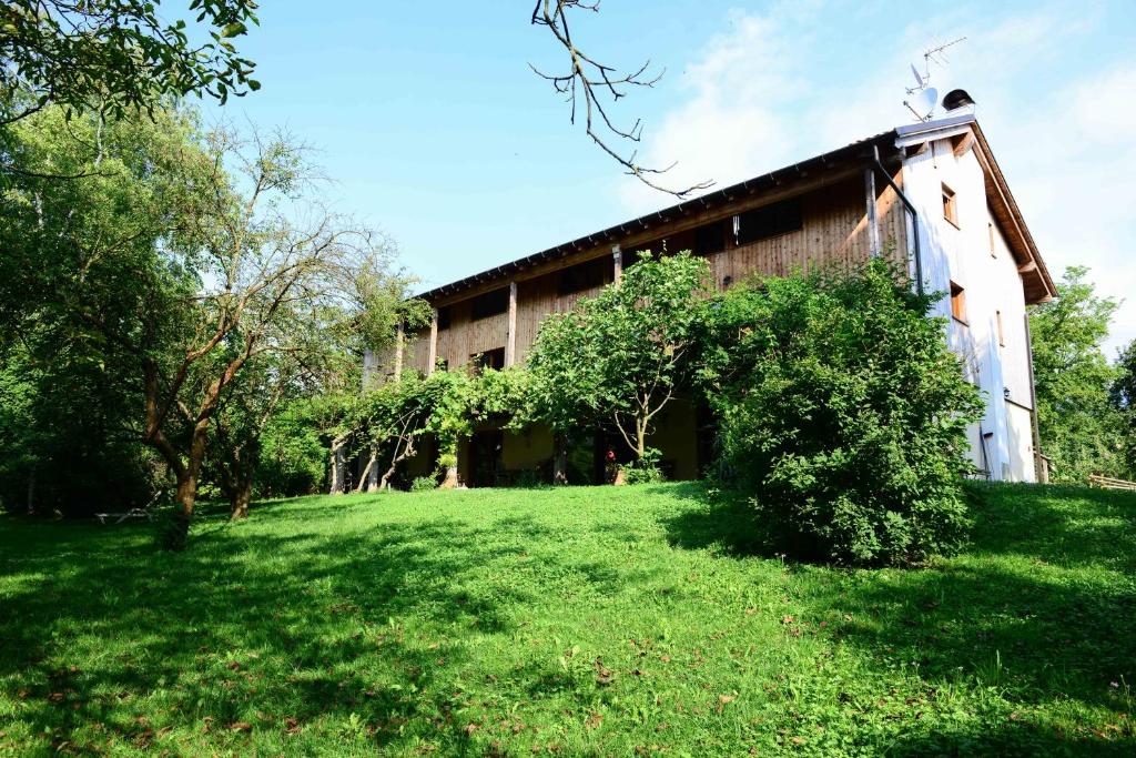 un edificio con un patio verde delante de él en BioAgriturismo Vegan Campo di Cielo, en Cesiomaggiore