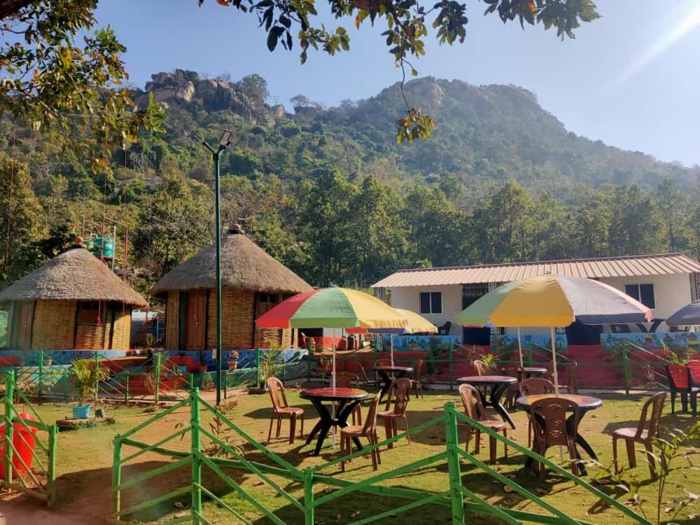 un groupe de tables et de chaises avec parasols dans l'établissement Chamtaburu Eco Resort, à Bāghmundi