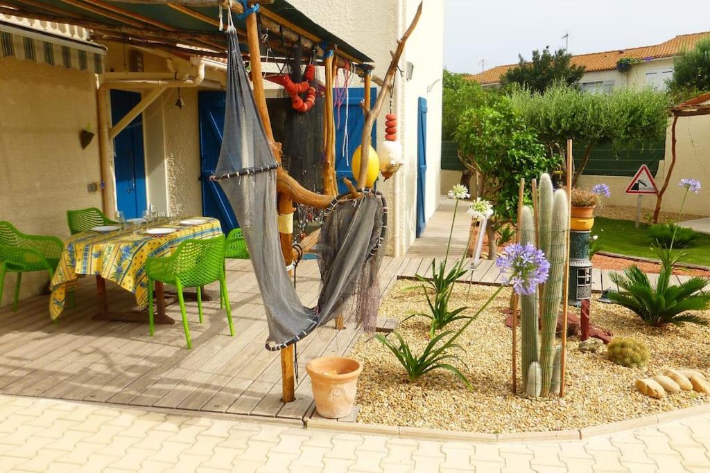 d'une terrasse avec un hamac, une table et des chaises. dans l'établissement Villa Evasion à Sète, à Sète