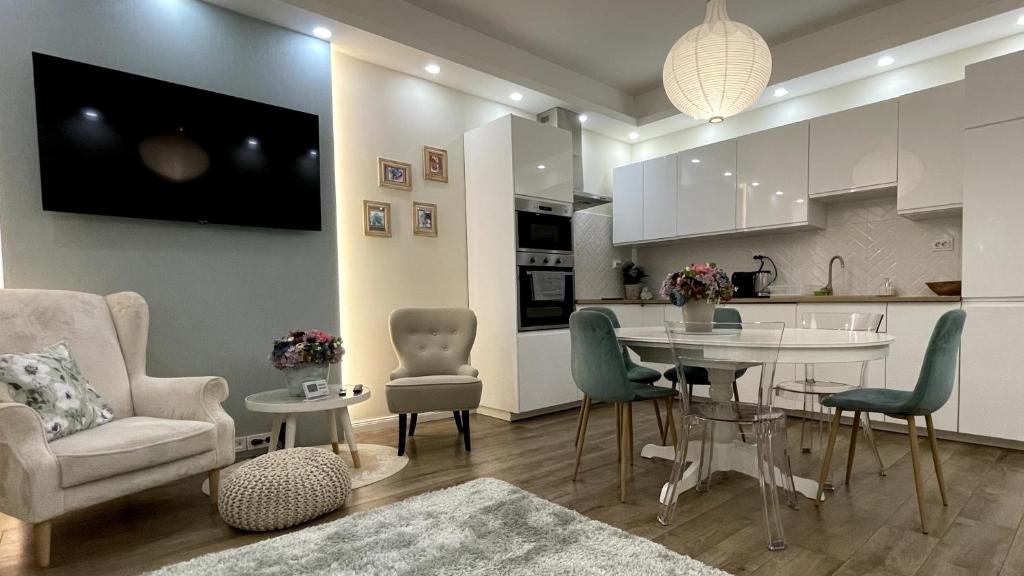 een keuken en een woonkamer met een tafel en stoelen bij Buda Garden Apartment in Boedapest