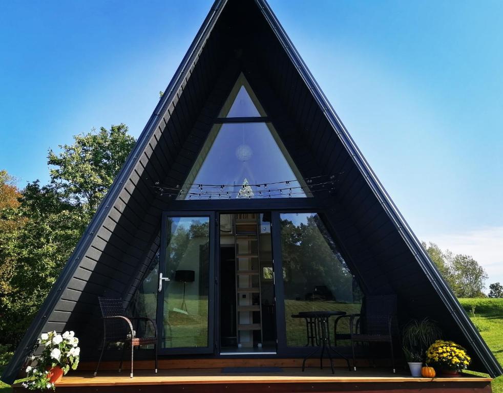 a triangular shaped house with a glass window at Rose Valley Cottage in Ieriķi