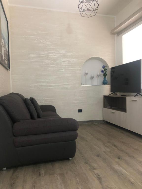 sala de estar con sofá y TV de pantalla plana en Casa Alessio, en Cesano Maderno