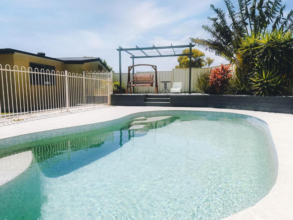 a swimming pool in a yard with a fence at Sunny Shores House with Private Pool in Lake Illawarra