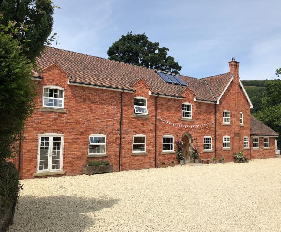 a large red brick building with white windows at The Old Coach House in Llangollen