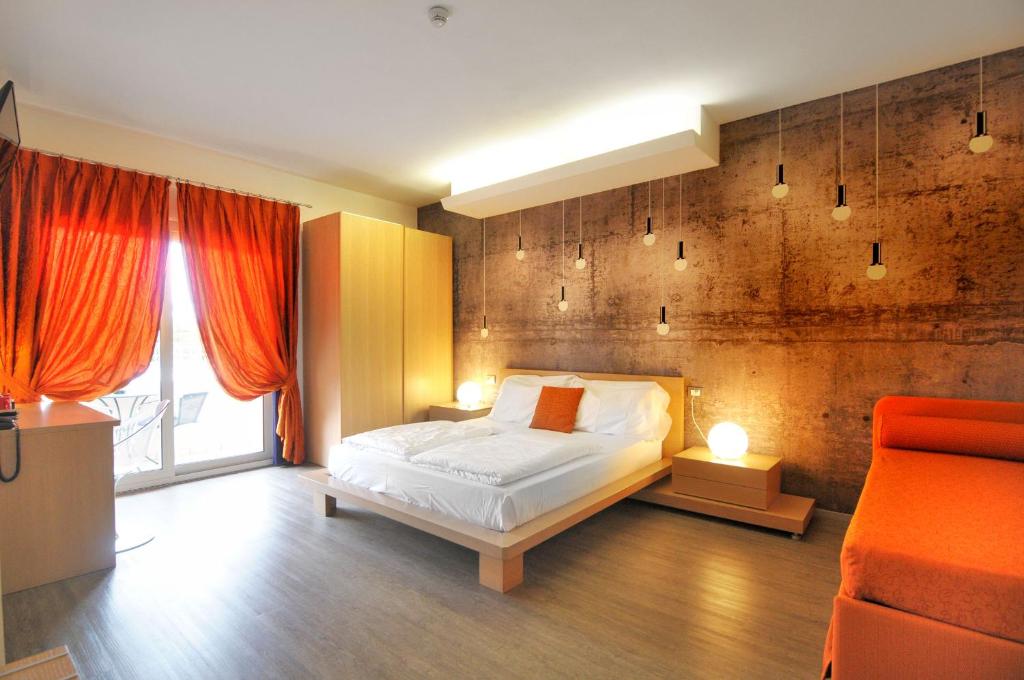 a bedroom with a bed and an orange couch at Eco Hotel Cleofe in Caorle