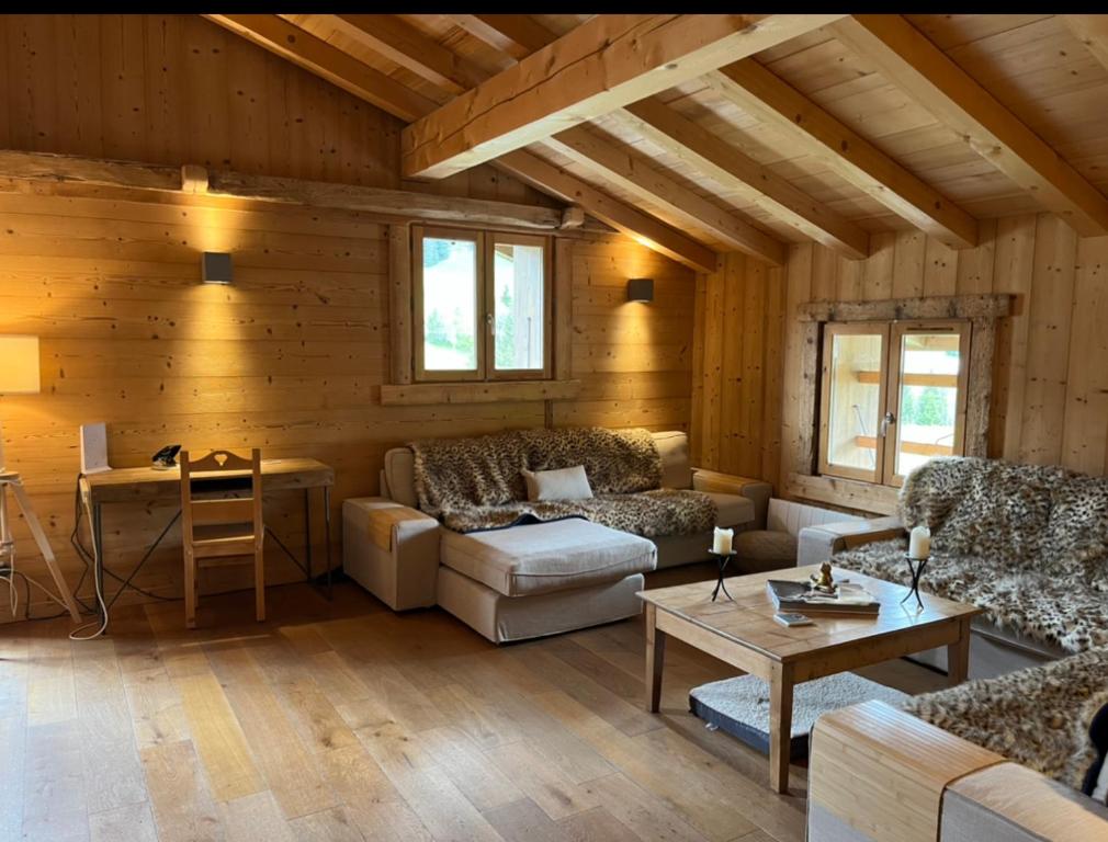 een woonkamer met een bank en een tafel bij Le Chalet du Crêt - 8 pers, tout confort avec Jacuzzi in Notre-Dame-de-Bellecombe