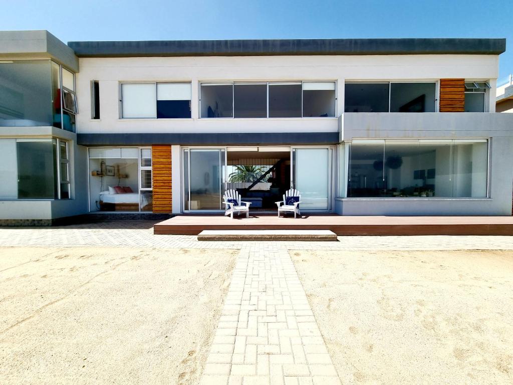 una casa con dos sillas delante en Henties Bay Haven Holiday Home, en Henties Bay