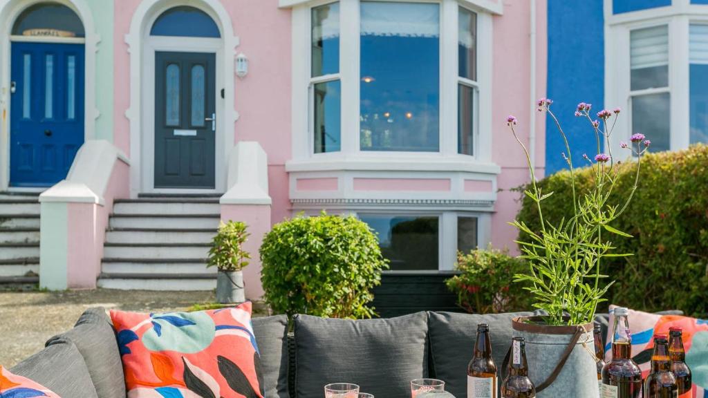 a table in front of a pink and blue house at Claremont in Llanfairfechan