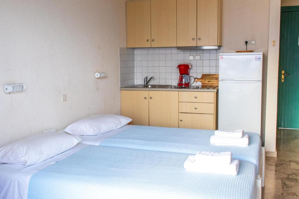 a small kitchen with a bed and a refrigerator at Galini Studios and Apartments in Lassi