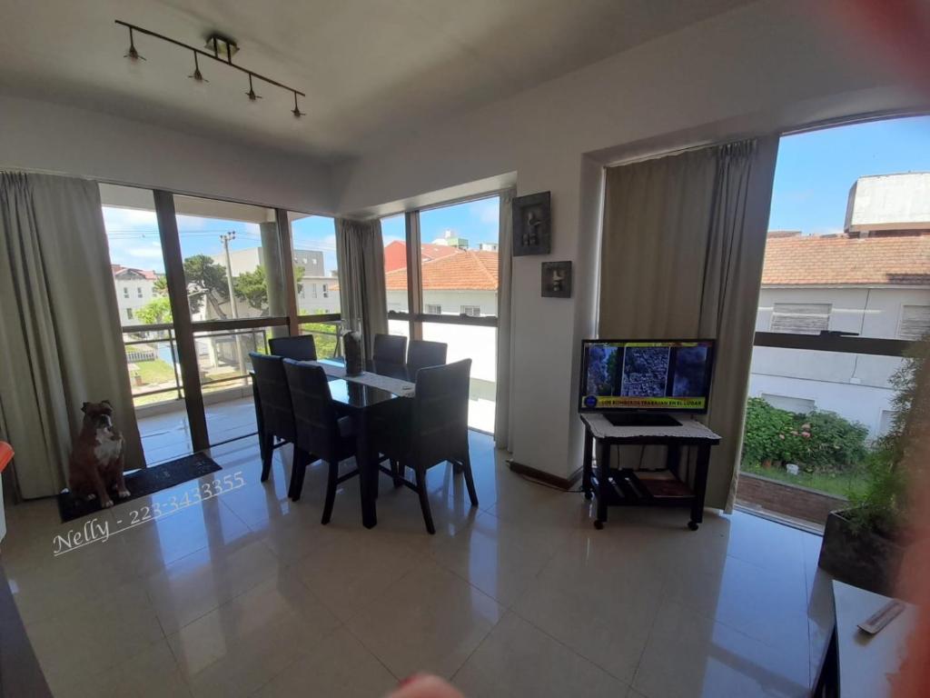 een eetkamer met een tafel en stoelen en een laptop bij Reflejo de Mar in Villa Gesell