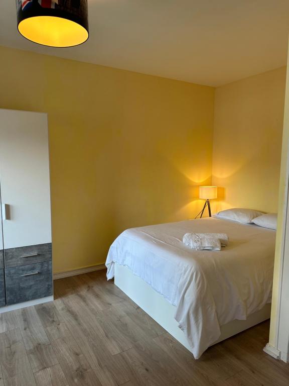 a bedroom with a bed and a yellow wall at Charmant studio très accueillant in Geneva