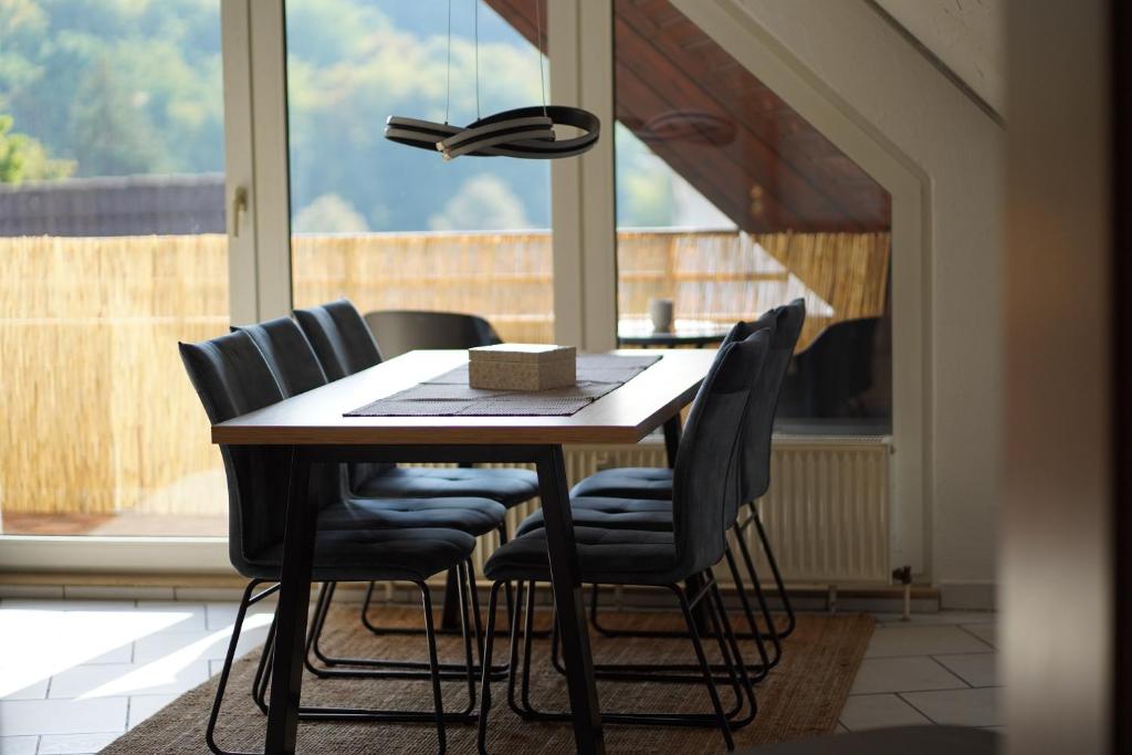 mesa de comedor con sillas y luz eólica en "SANO" Apartments - Herdecke - Maisonette - Balkon - Tiefgarage en Herdecke