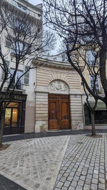 een gebouw met een grote houten deur in een straat bij Chambre privée centre de Paris proche Marais in Parijs