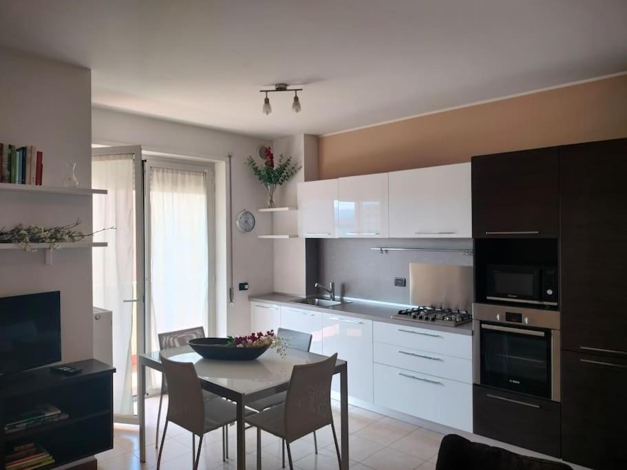 een keuken met een tafel en stoelen en een keuken met witte kasten bij Casa quinto piano - intero appartamento con garage in Vicenza
