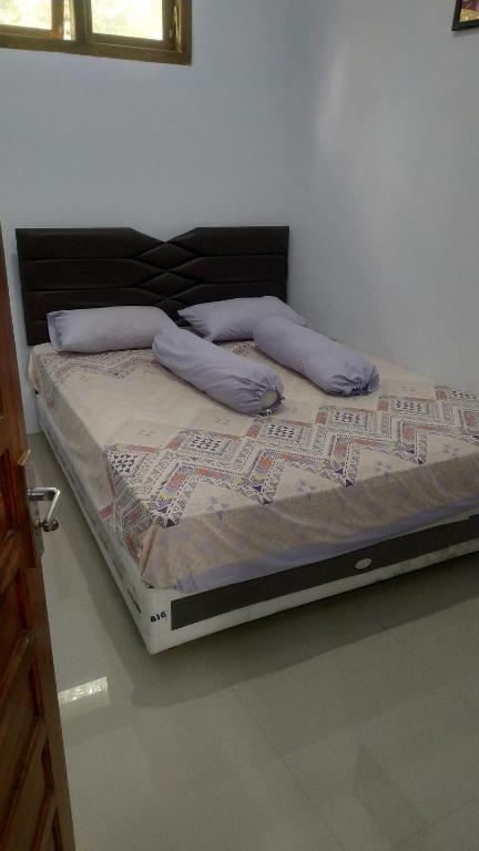 een bed met twee kussens in een kamer bij Soraya Homestay in Tulungagung