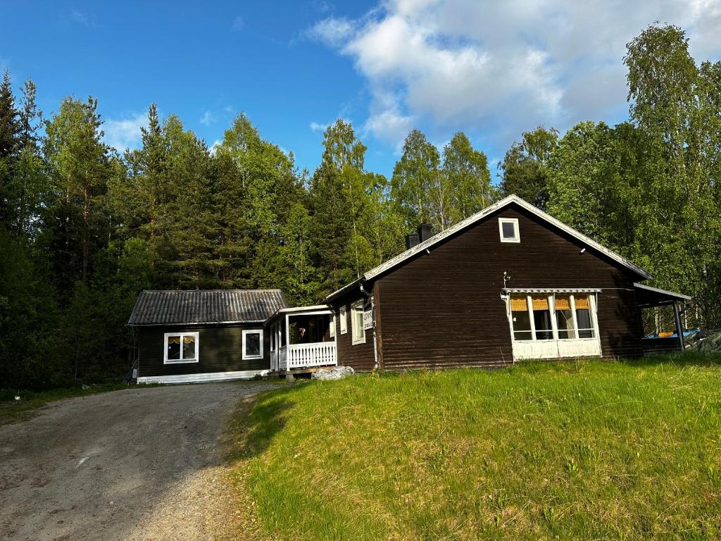 a house on a road next to a field at Bungalow Östavall Skogsvägen 20 in Haverö