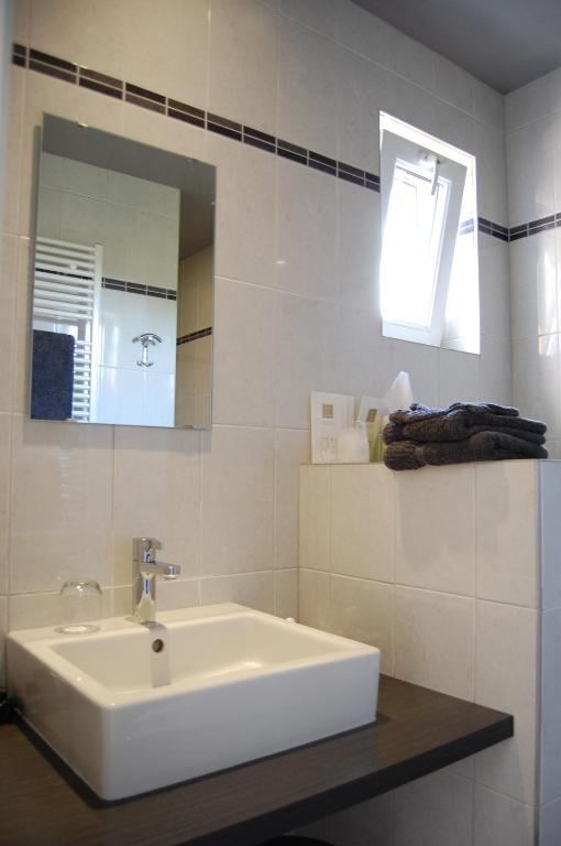 a white bathroom with a sink and a mirror at Apollonia in Aalter