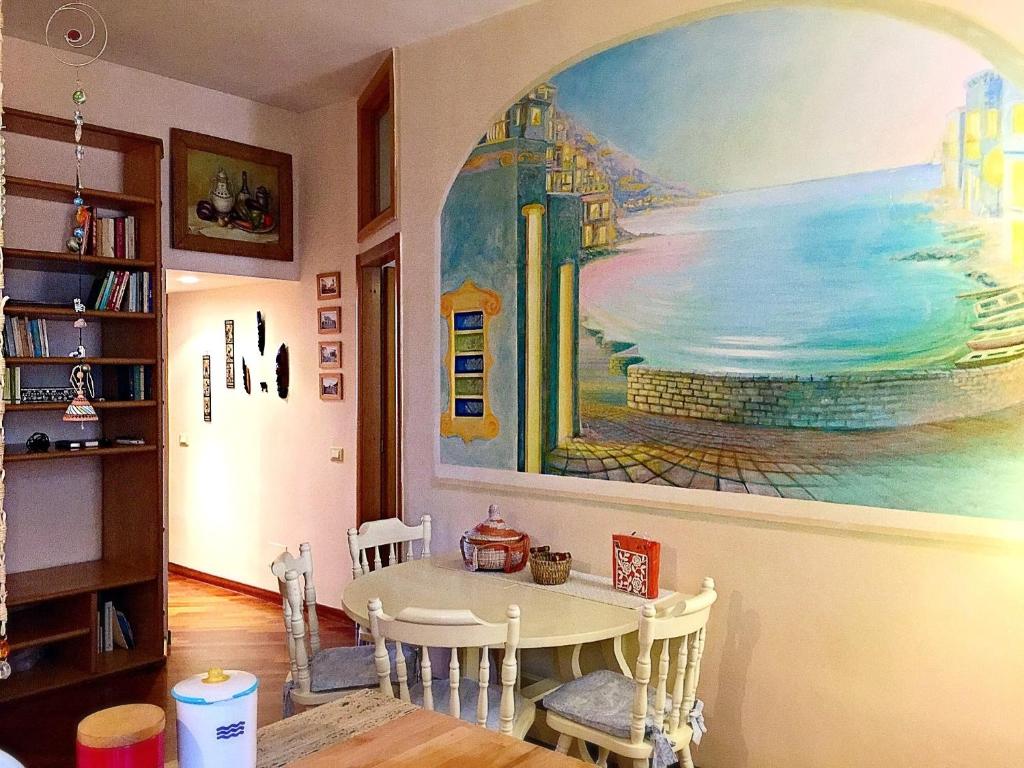 una sala da pranzo con un grande dipinto sul muro di Casa Vacanze Seahorse a Salerno