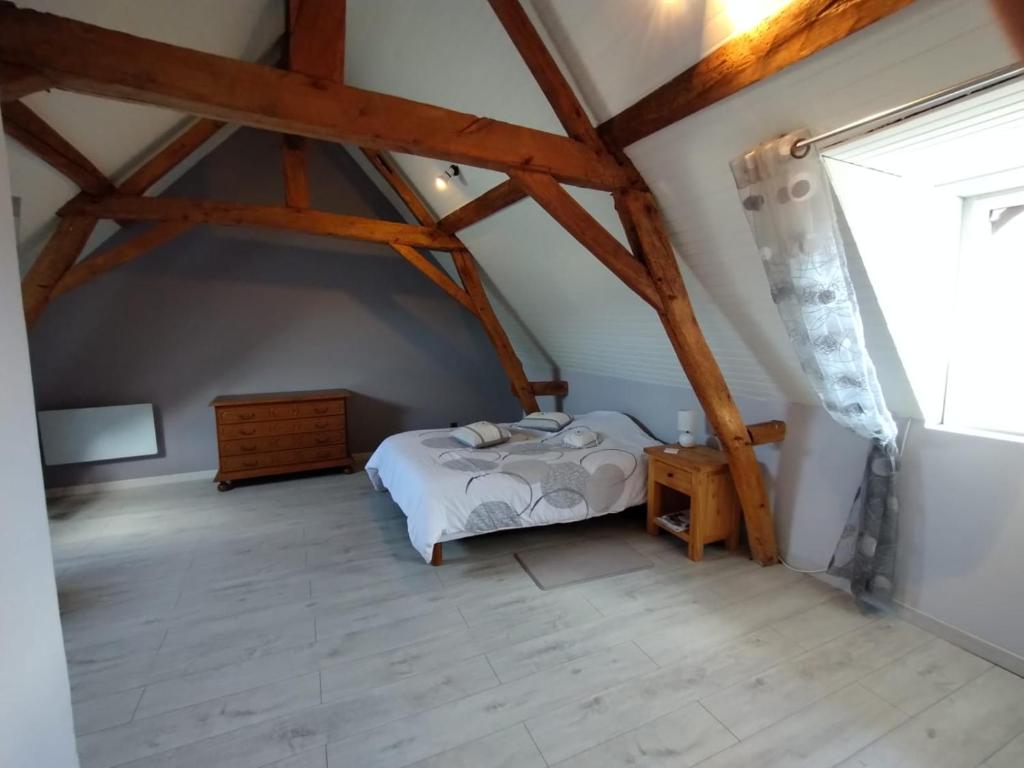 sypialnia z białym łóżkiem na poddaszu w obiekcie Le moulin neuf w mieście Saint-Nicolas-de-Bourgueil