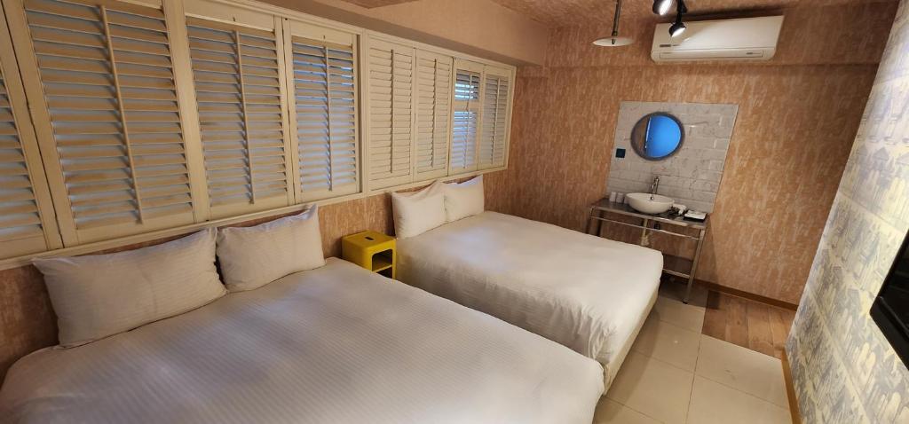 Cette petite chambre comprend 2 lits et un lavabo. dans l'établissement Cheers Loft Self Check-in Hotel, à Taipei