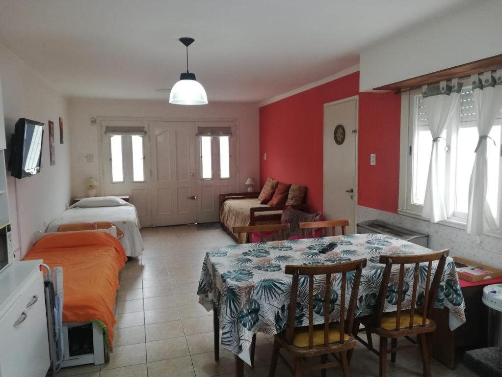 sala de estar con mesa y dormitorio en La casita de Punta Mogotes en Mar del Plata