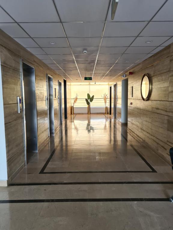 a hallway in a building with a large wall at 1 Bed Modern Apartment, Pool, Gym, Cinema in Lahore