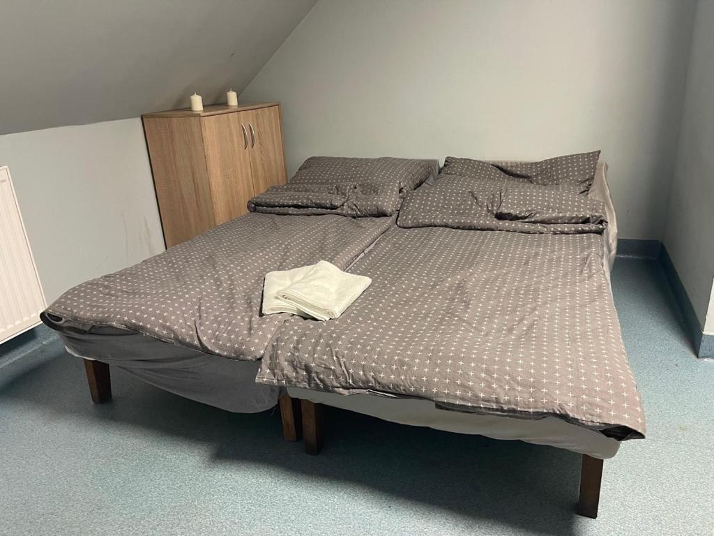 ein Schlafzimmer mit einem großen Bett und einem Holzschrank in der Unterkunft Lawendowa Przystań pokój rodzinny Nr 7 poddasze 