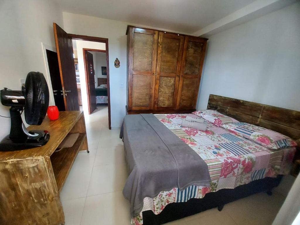 um quarto com uma cama e uma secretária com uma ventoinha em Apbananeiras - Condomínio Sonhos da Serra em Bananeiras