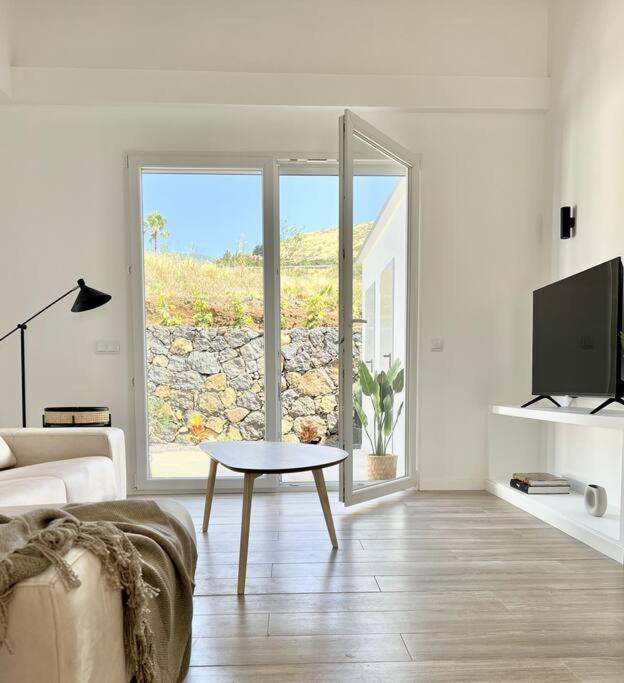 un soggiorno con divano e tavolo di fronte a una finestra di LA GRAMA V, comodidad y excelente ubicación a Breña Alta