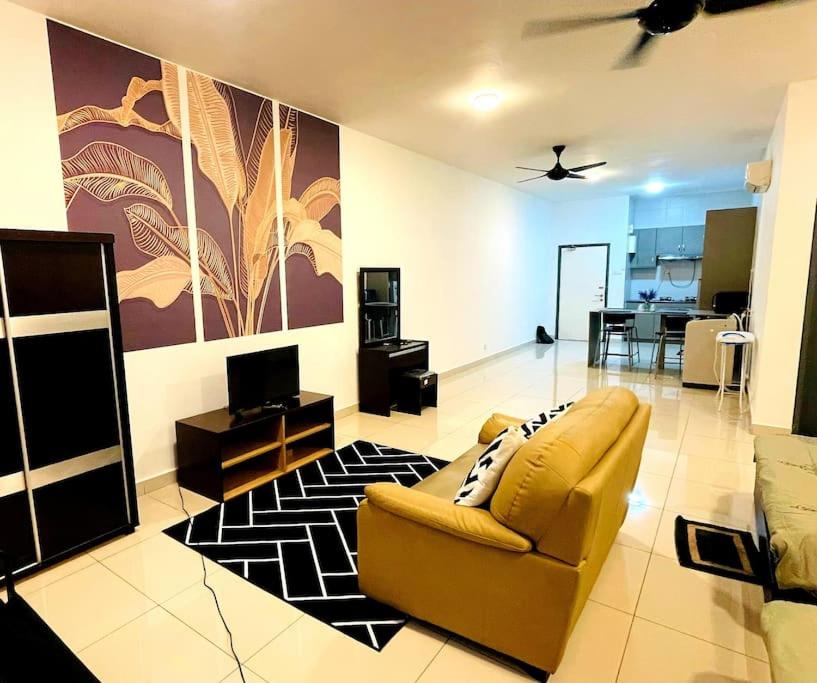 a living room with a yellow couch and a television at Damen/subang jaya, studio for 4 in Subang Jaya