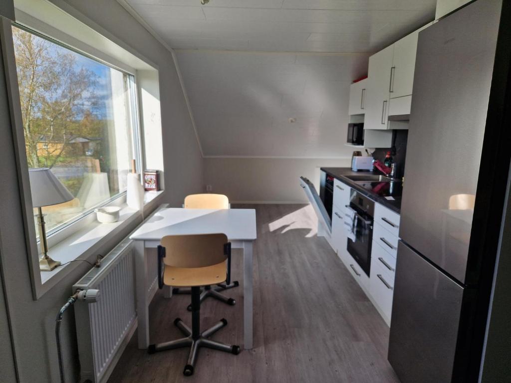 cocina con mesa, sillas y ventana en Serenity Cottage, en Närpiö