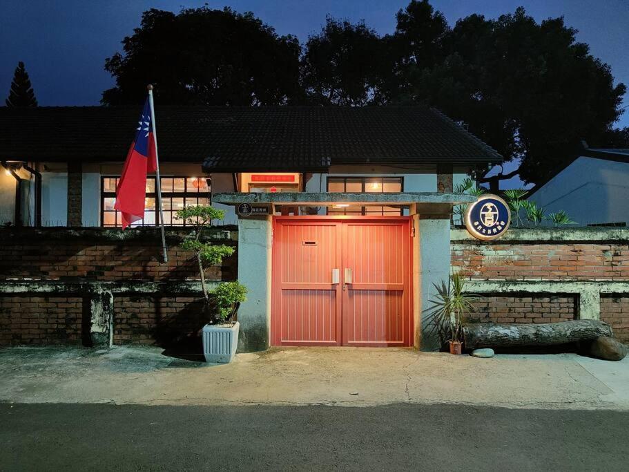 a house with a red door and a flag at Soho工房眷村生活體驗館 in Kaohsiung