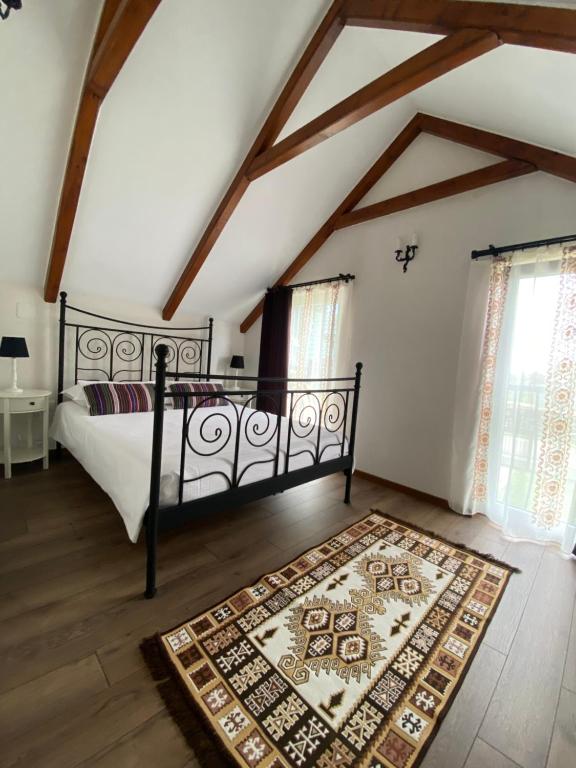 a bedroom with a bed and a rug at Casa Moldovan ( Coltisorul meu de rai) in Ocna Şugatag