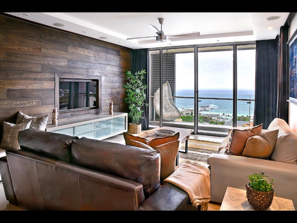a living room with a couch and a television at The Crystal 203 Camps bay - back-up power in Cape Town