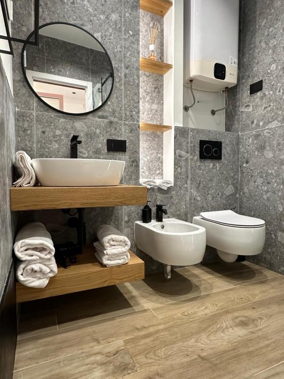 uma casa de banho com um lavatório, um WC e um espelho. em Ossidiana Rossa Elegant Suite Vulcano em Vulcano