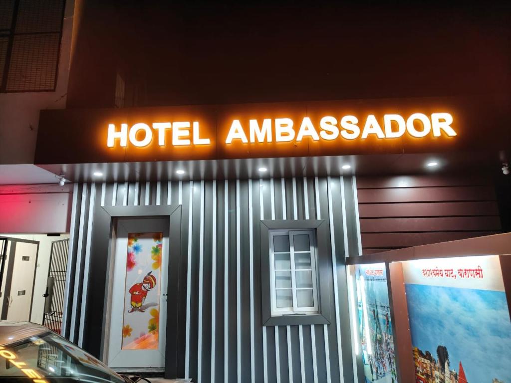 um sinal de embaixador do hotel na lateral de um edifício em The Hotel Ambassador Inn em Varanasi